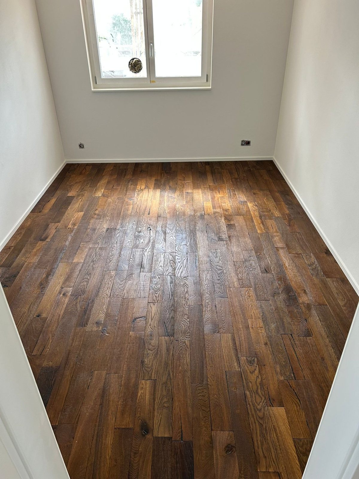 Zimmer mit dunklem Holzparkett