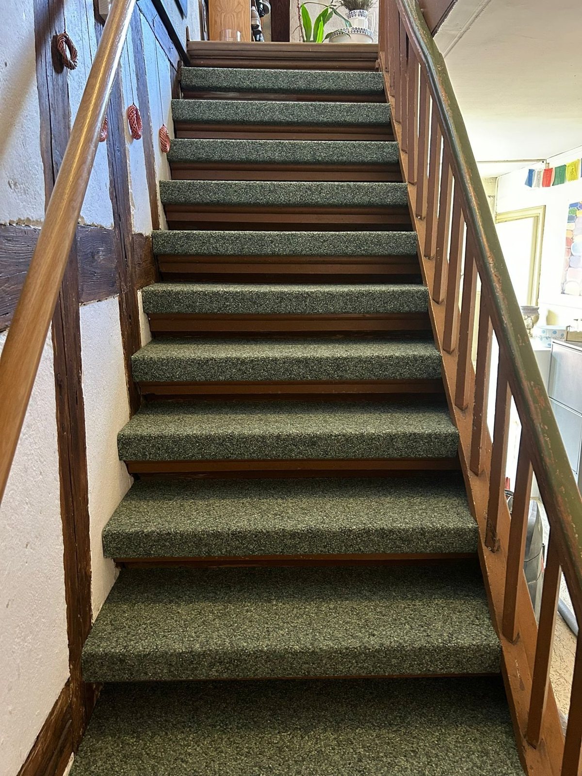 Treppe mit Teppich und Holzgeländer